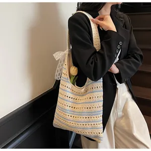 Detail of striped crochet beach bag with lace bow decoration and hollow woven texture