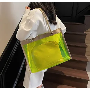 Detail of neon green transparent PVC beach tote bag with rope handle on model