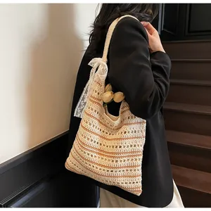 Close-up of the crochet knit tote bag featuring a decorative white lace bow and striped texture