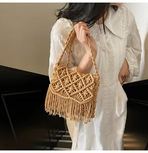 Detail of bohemian hand-woven shoulder bag with geometric patterns and long fringes