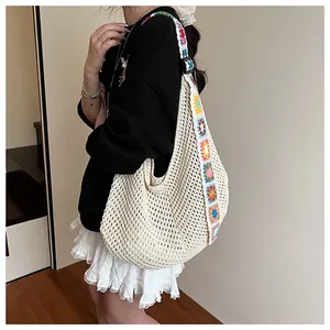 Detail of bohemian knit tote bag showing colorful crochet sun flower patterns on wide strap