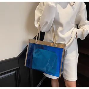 Detail of blue transparent PVC beach tote bag featuring golden trim and rope handles