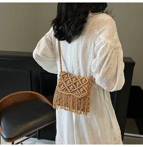 Close-up of bohemian macrame woven crossbody bag with long fringes and geometric texture
