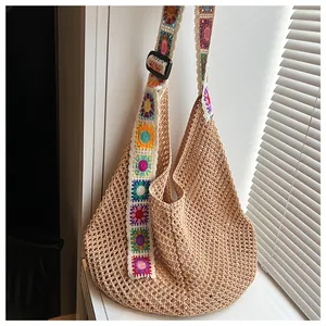 Detail of colorful crochet sunflower strap on a beige hollow knit shoulder beach bag