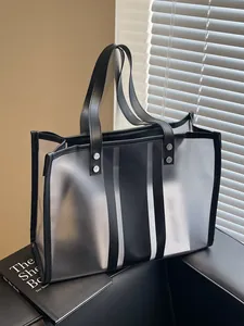 Transparent PVC tote bag with black faux leather trim and silver metal rivet reinforcement