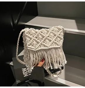 Close-up of bohemian hand-woven white tassel bag with intricate diamond mesh textures
