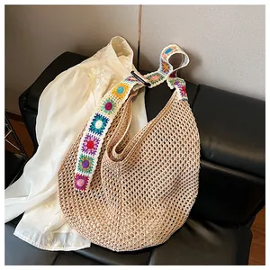 Detail of bohemian knit shoulder bag with colorful floral embroidery and mesh texture
