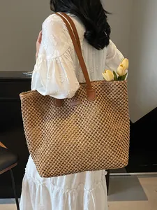 Grand sac cabas en paille avec bandoulières en cuir marron et texture tissée pour l'été