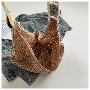 Detailed close-up of bohemian crochet knit tote bag with colorful floral strap details
