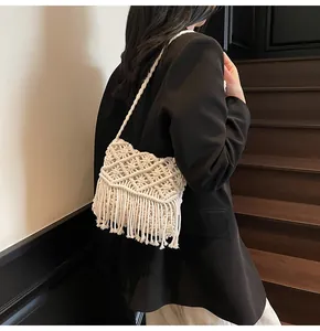 Detail of woven boho shoulder bag with tassels and intricate diamond hollow patterns