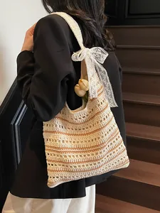 Striped crochet tote bag with white lace bow and brown stripes on model