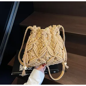 Detail of handmade crochet bucket bag with diamond weave, drawstrings and wooden beads