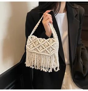 Detailed close-up of handmade white macramé weave and tassels on the bohemian beach bag