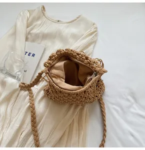 Top view of a khaki woven bucket bag with metal zipper and chunky knit shoulder strap