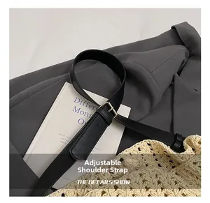 Détail de la bandoulière réglable en cuir noir avec boucle sur sac en crochet beige