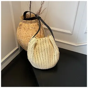 Détail de la texture crochetée beige avec bandoulière réglable en cuir noir