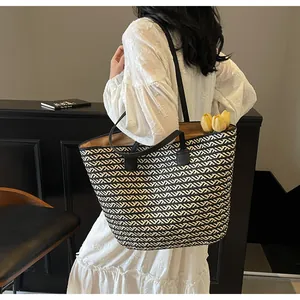 Close-up of a large woven tote bag with a chic black and beige chevron pattern detail