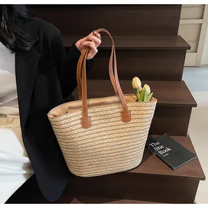Close-up of a woven straw tote bag with brown handles and elegant yellow tulips inside