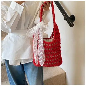 Nahaufnahme der roten Häkel-Schultertasche mit einer großen weißen Spitzen-Schleife