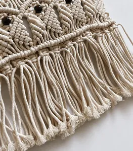 Detail of bohemian cotton fringe bag featuring intricate weaving and dark wood beads