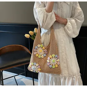 Detail of crochet tote bag with colorful floral patterns and hollow knit texture