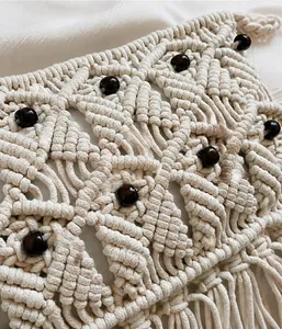 Detail of bohemian macramé bag showing 3D weave textures, wooden beads and fringe tassels