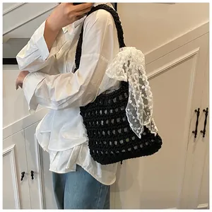 Detail der schwarzen Häkeltasche mit Netzmuster und großer weißer Spitzenschleife