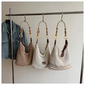 Detail view of hollow woven beach tote bags with wooden bead straps in three colors
