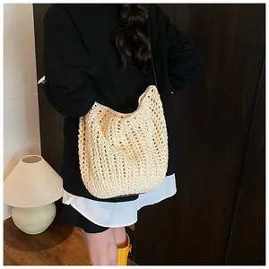 Gros plan du sac fourre-tout au crochet crème avec texture tricotée et bandoulière noire