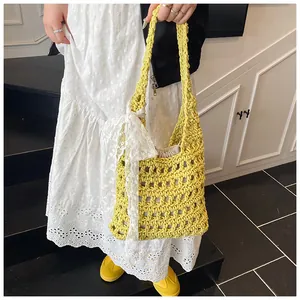 Detail der gelben Häkeltasche mit weißer Spitzenschleife und Kordelzug-Innentasche