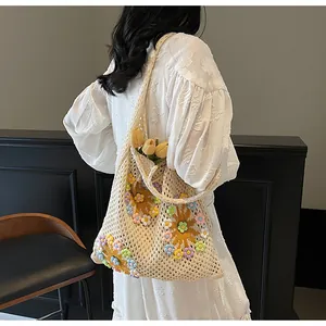 Close-up of beige crochet tote bag with 3D floral accents and openwork knit pattern