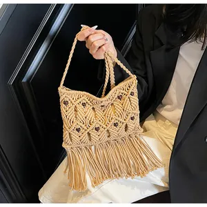 Detail view of handmade beige woven bohemian bag featuring wooden beads and long tassels