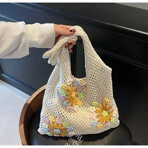 Detailed crochet texture of cream knit tote bag with colorful floral 3D appliqués