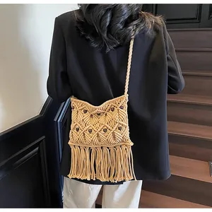 Detail of bohemian macrame crossbody bag with wooden beads and long fringe tassels