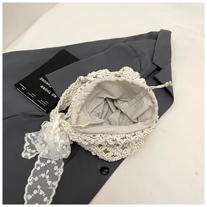 Detail der Häkel-Beuteltasche mit Kordelzug-Futter und eleganter weißer Spitzenschleife