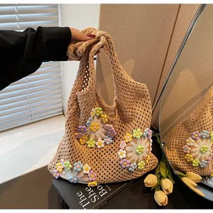 Detail of handmade crochet tote bag with colorful 3D floral accents and daisy patterns