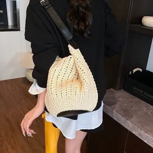 Détail d'un sac à bandoulière en crochet beige avec base en cuir noir en intérieur