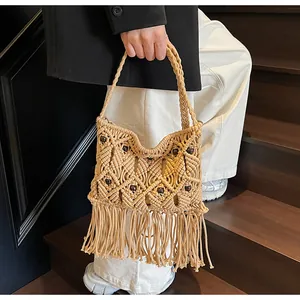 Detail of bohemian woven handbag with cotton fringe accents and wooden bead decorations
