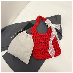 Details der roten Häkeltasche mit weißem Spitzenschal und beigem Kordelzug-Innenbeutel