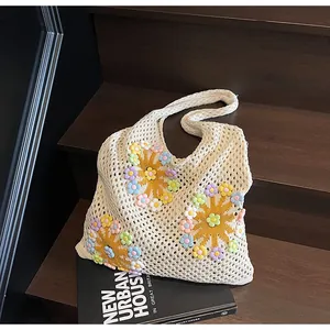 Detail of hollow knit tote bag with handmade 3D floral accents and woven texture