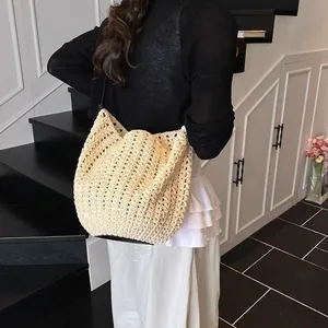 Détail d'un sac cabas en crochet beige avec maille ajourée et fine bandoulière en cuir noir