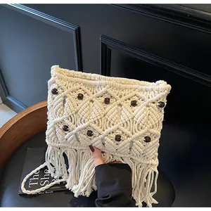 Close-up of cream macrame woven bag featuring dark wood beads and long fringe details