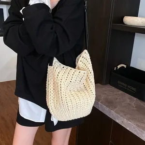 Détail du sac à bandoulière en crochet crème avec motif ajouré et fine bandoulière noire