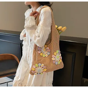 Detail of hollow knit tote bag featuring colorful floral embellishments and mesh pattern