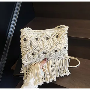 Close-up of bohemian woven cotton bag with wooden beads and long fringe tassels