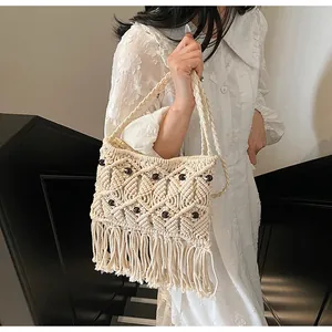 Detail of bohemian macrame fringe bag with woven lattice patterns and dark beads