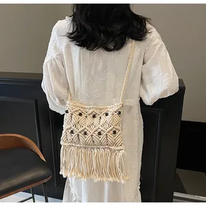 Detail of macramé shoulder bag with dark wooden beads and long fringe tassels