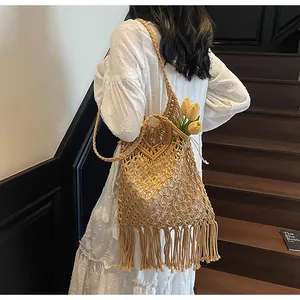 Detail of bohemian woven shoulder bag with long tassels and geometric mesh texture