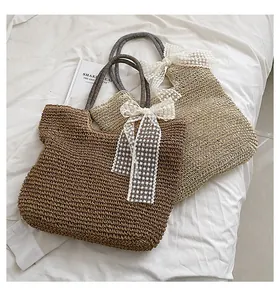 Detail of woven straw tote bags with lace bows and striped handles for summer vacation