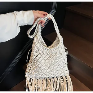 Detail view of woven macrame bag showing intricate mesh patterns and long fringe tassels